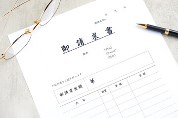 請求書 - 取引先へ宛てて請求書を準備する、ビジネスシーンのイメージ  © PJM