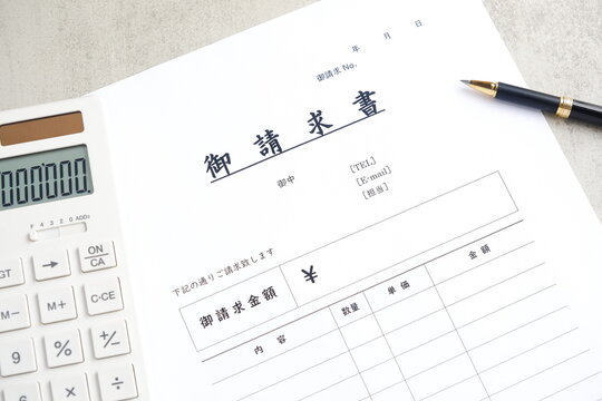 請求書 - 取引先へ宛てて請求書を準備する、ビジネスシーンのイメージ
