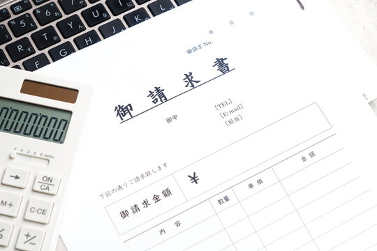 請求書 - 取引先へ宛てて請求書を準備する、ビジネスシーンのイメージ
