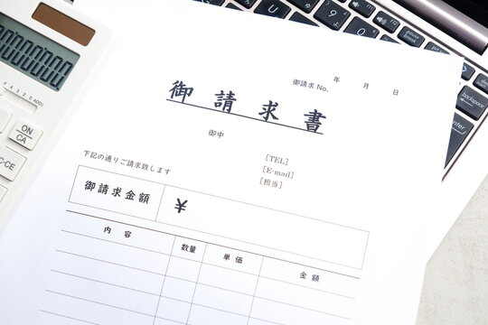 請求書 - 取引先へ宛てて請求書を準備する、ビジネスシーンのイメージ
