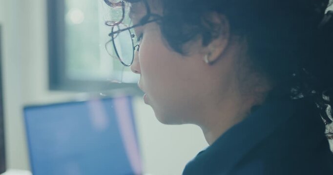 Close-up young Black female robotics engineer coding AI software for robotic arm in laboratory. Embedded system, firmware testing, machine learning, industrial automation, future technology concept.