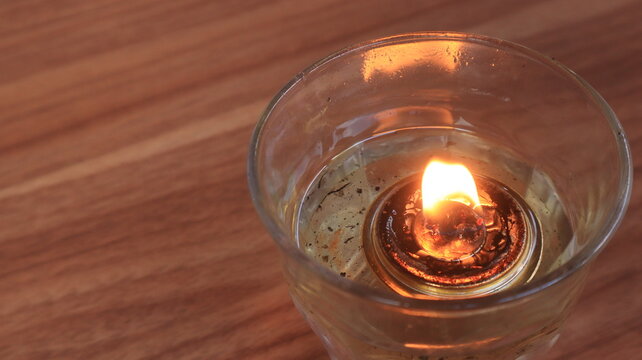 A candle with a low flame is placed on the dining table, to ward off flies.