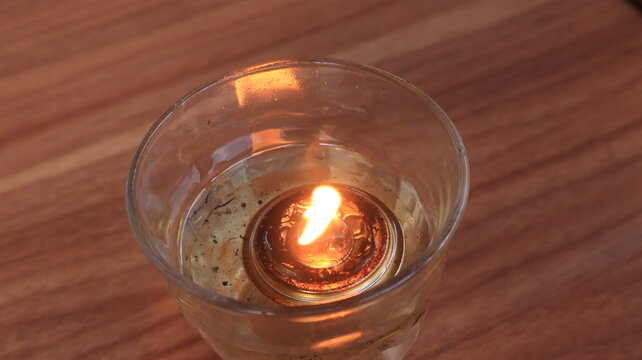 A candle with a low flame is placed on the dining table, to ward off flies.