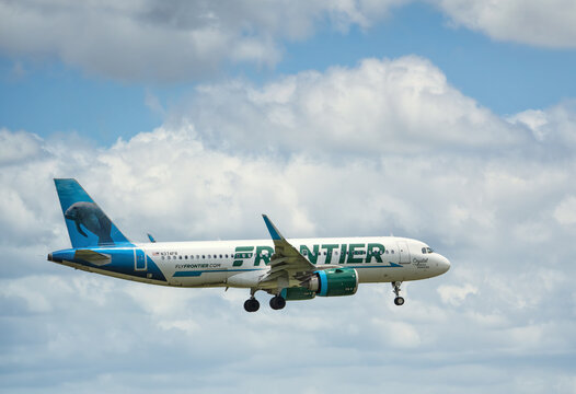 Frontier Airlines aircraft Airbus A320neo airborne over the Dallas Fort Worth International Airport (DFW). Crystal the Florida Manatee livery. Storm clouds.