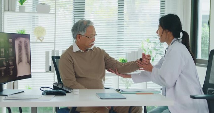 Young Asian female doctor examining senior man arm and shoulder at clinic. Physical therapy rehab, joint pain treatment, medical health care, professional physician support, muscle injury concept.