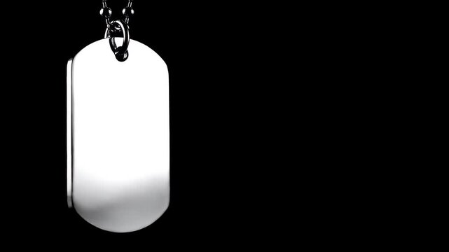 Dog tag pendant hanging on a metal chain isolated on a black background for military jewelry design