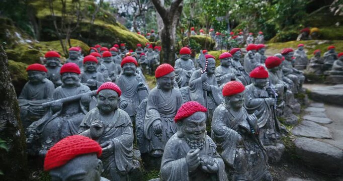 Stone Rakan Statues with Red Knit Caps at Japanese Temple - Slow, Steady Cam Shot