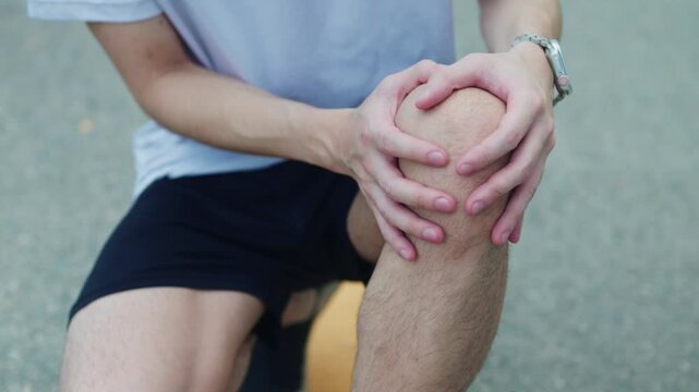 Man Holding Painful Knee Outdoors During Exercise, Sports Injury Close Up 4K