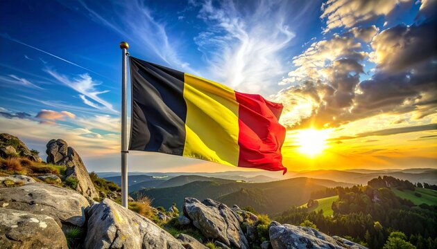 Belgium national flag waving against dramatic sky and rocky landscape, symbolizing heritage, pride, resilience, and national identity.
