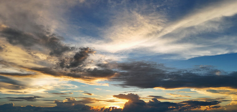 Golden clouds drift across twilight sky