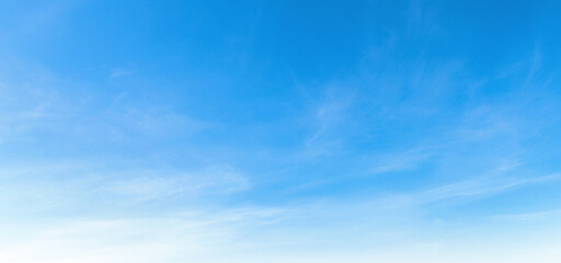 Naklejka premium Clear blue sky with wispy clouds drifts gently above