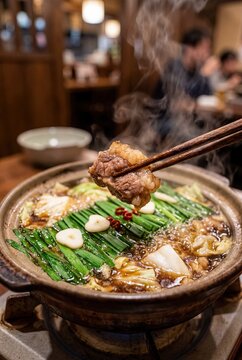 Japanese motsu nabe hot pot with beef offal and vegetables closeup