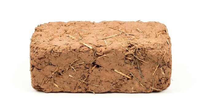 Traditional adobe mud brick with straw, sustainable clay building block for eco-friendly construction, rustic sun-dried earth brick on white background