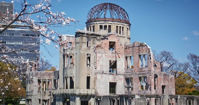 People Passing By Hiroshima Peace Memorial Dome with Cherry Blossoms In Japan