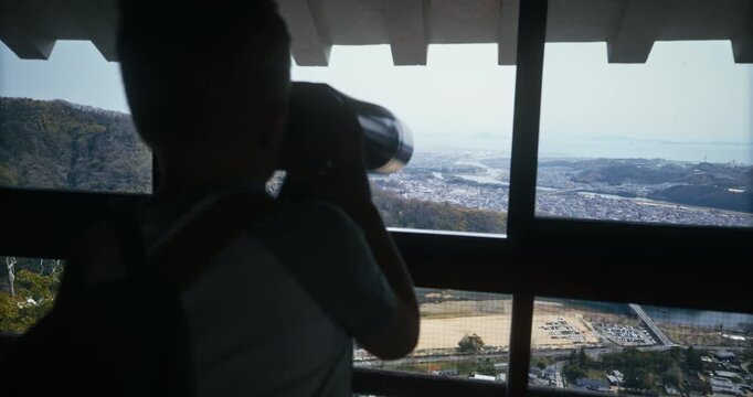 Little Boy Uses Coin Binoculars at Observation Deck In Hiroshima Japan