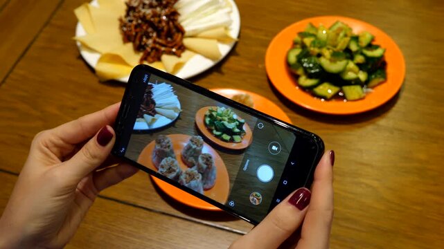 Customer woman take photos of meals at Chinese restaurant, make picture of Shumai then whole set of three dishes, dumplings, Jing Jiang Rou Si pork with tofu and pai huang gua - smashed cucumber salad