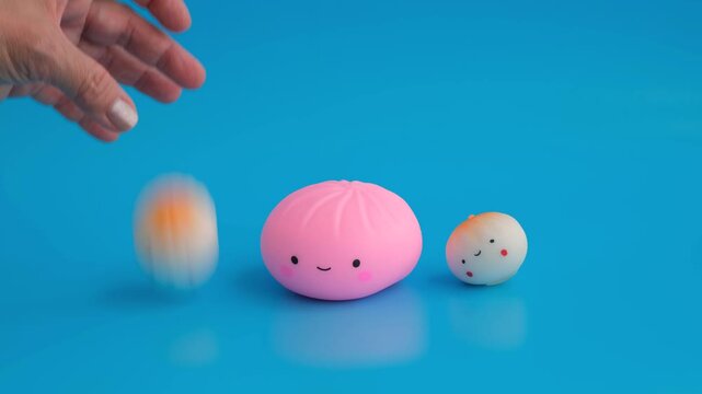 Three soft anti-stress toys in the shape of a dumpling with a happy face on a blue background