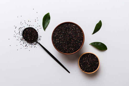 quinoa seeds in bowl and spoon on colored background. Healthy kinwa in small bowl. Healthy superfood