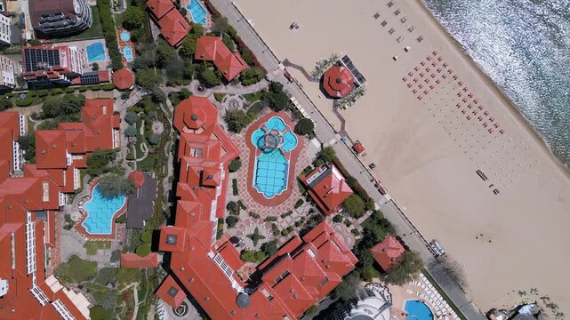 Top down aerial view of luxury beachfront resort hotel with pools
