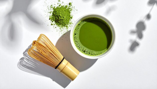 A serene scene of a matcha whisk and bowl on a table with green tea leaves.