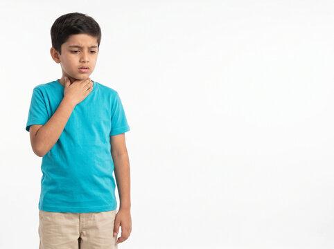 Young Indian school boy with sore throat discomfort isolated on white background for pediatric healthcare awareness and medical advertising campaigns