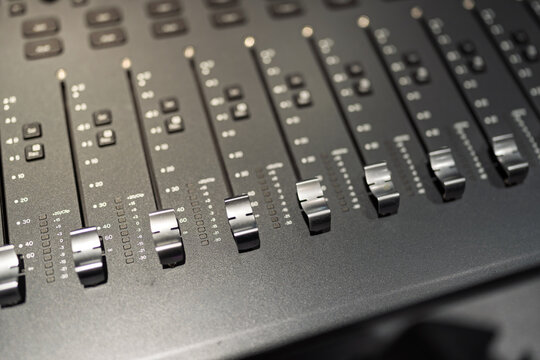 close up view of professional audio mixer faders in recording studio