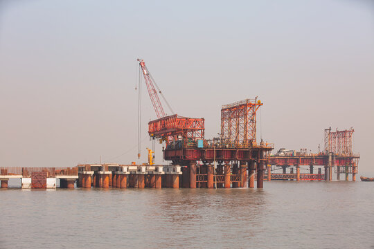 Piling cranes on barge hammering a concrete piles into sea - Offshore oil and gas sea construction at port of Mumbai, india