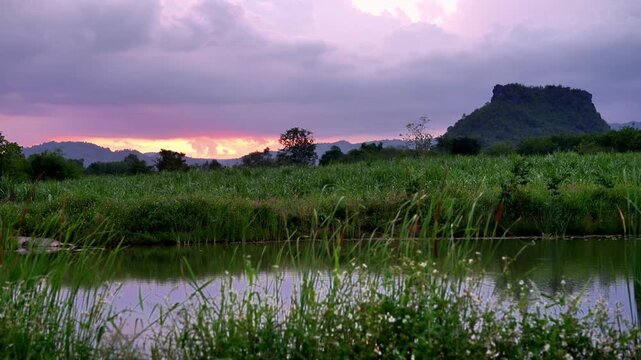 Sunrise over calm lake with river reflection, clouds and beautiful natural landscape