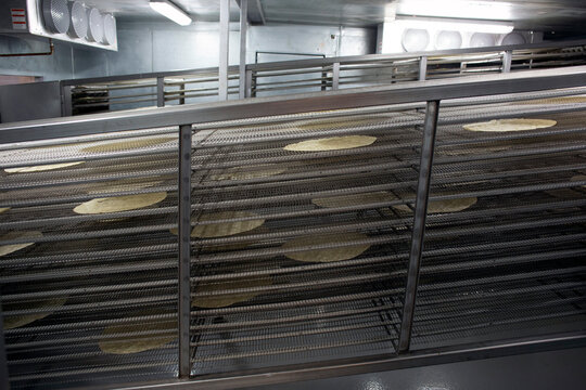 Freshly made tortillas cooling on industrial racks