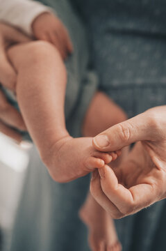 Close-up of parent gently holds newborn baby's tiny foot