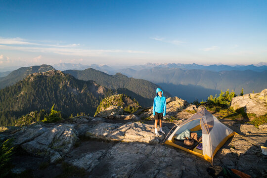 Young person camping on a scenic mountaintop