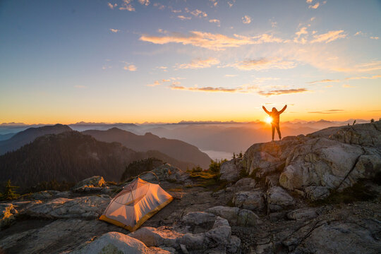Hiker celebrates an epic mountain top sunrise