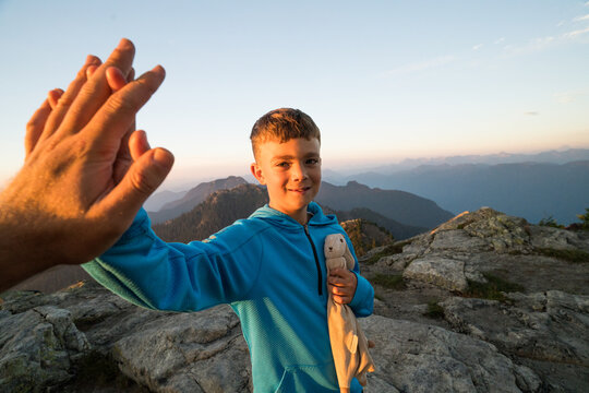 Boy high-fives his dad during hiking trip