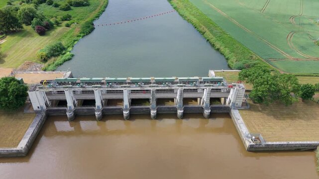 Close-up aerial view of a massive tidal outfall barrier and coastal drainage infrastructure for regional water control in Kings Lynn, UK.