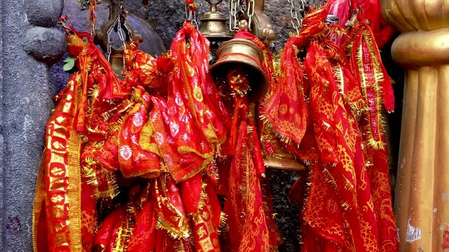 Tilt-Up shot of Maa Kamakhya temple sacred bells where chunris and devotional cloths are tied as offering
