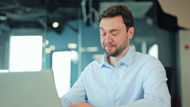 Close-up of lazy corporate worker or IT specialist leaning chin on palm during tedious routine job at laptop. Exhausted employee or freelance designer wasting time because of unmotivated mood