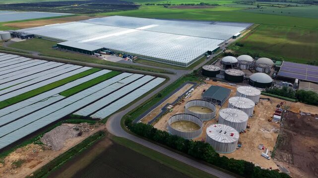 Aerial view of a massive glass greenhouse complex with an anaerobic digestion energy plant in Cambridgeshire, UK
