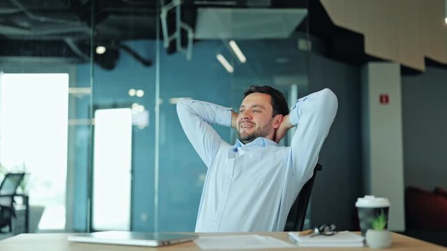 Happy corporate manager or IT specialist resting after successfully completed project at laptop. Cheerful employee or freelance worker smiling and feeling relaxed with finished task at office desk