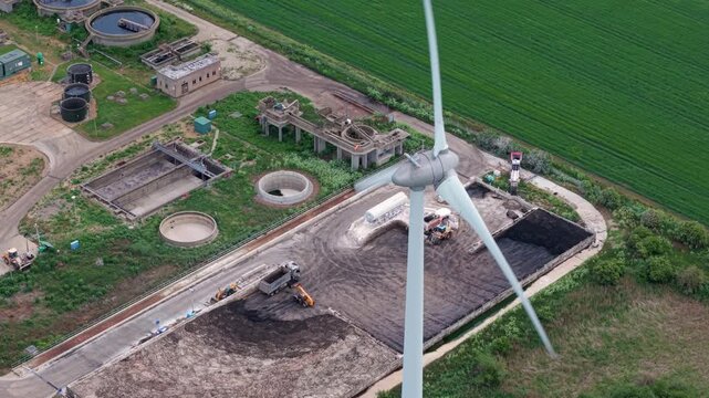 Aerial view of Wastewater Treatment Works featuring a single on-site wind turbine for renewable power, Cambridgeshire, UK