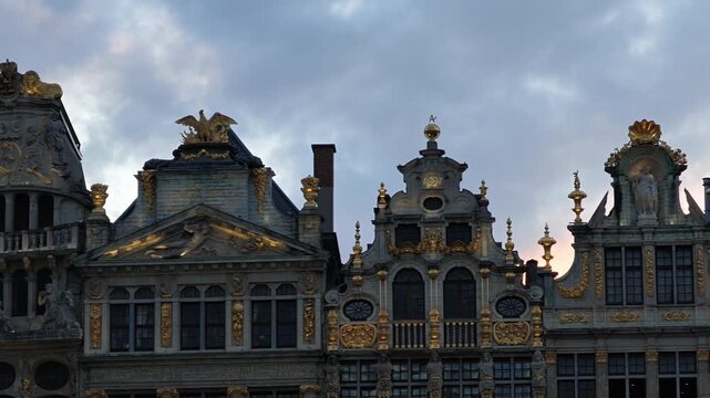 Grand Place Belgium sunset. Low-angle 4K video looking up at the majestic Gothic tower of the Brussels Town Hall between historic guild houses in the famous Grand Place market square.