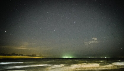 Fototapeta premium Starry Night Sky Over Long Exposure Ocean Waves