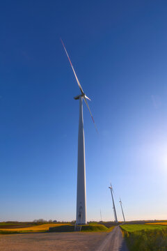 Wind turbines at sunset in green field &ndash; renewable energy, clean power, sustainable future.