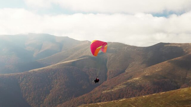 Paragliding in highland against giant forestry mountains