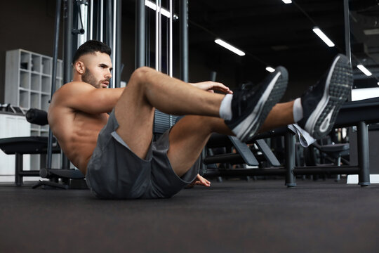 Sporty man stretching and warm-up doing special exercises for muscles before work his body out.