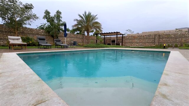 Private backyard swimming pool with loungers and pergola