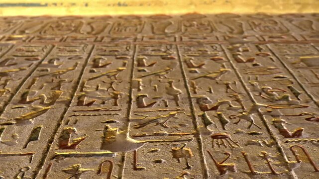 A low-angle, close-up perspective of a beautifully carved limestone wall inside the Tomb of Ramesses IV (KV2) in the Valley of the Kings, Luxor, Egypt.