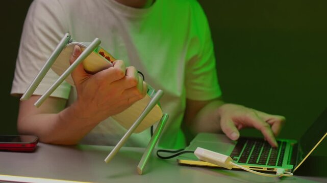 Annoyed person repeatedly slamming Wi Fi router on table due to slow, nonexistent internet connection trying to work on laptop. Concept of bad signal and technology frustration