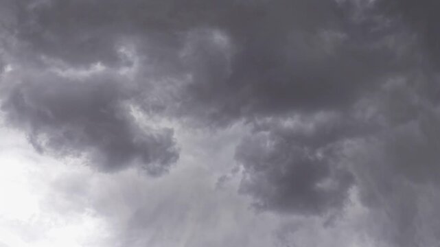 A timelapse of dark, rapidly forming storm clouds overtaking the sky. The dense, shifting overcast cover illustrates severe atmospheric changes, providing visual media for climate and weather topics.