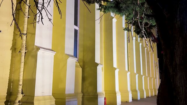 historic heritage building exterior featuring classical columns and dramatic nighttime lighting