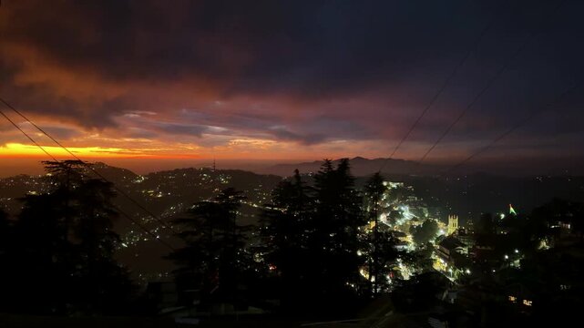 dramatic sunset over shimla cityscape with glowing horizon and mountain silhouettes at dusk